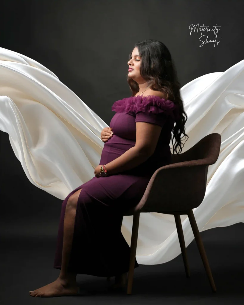 Close-up maternity belly shot with hands of parents during indoor maternity photoshoot in Jamshedpur