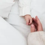 Newborn baby hand holding mother’s finger during lifestyle newborn photography session in Kolkata