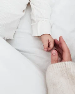 Newborn baby hand holding mother’s finger during lifestyle newborn photography session in Kolkata