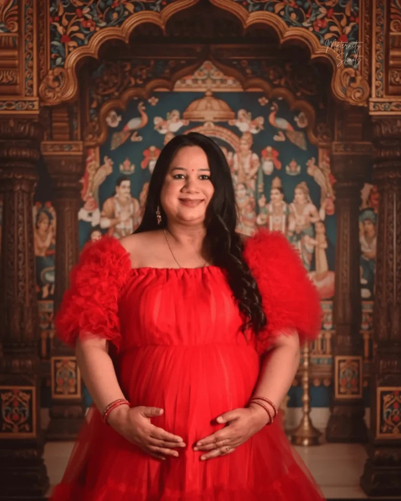 studio maternity photoshoot in Kolkata with red gown royal traditional backdrop