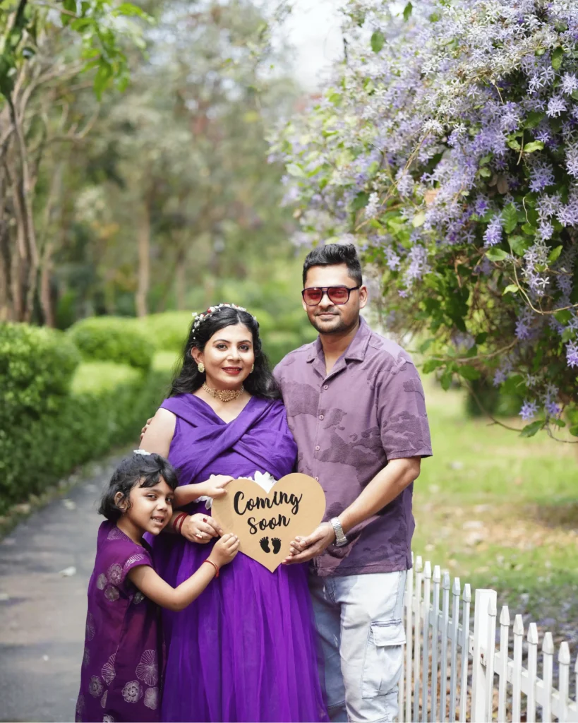 family maternity photoshoot in Kolkata with couple and child outdoor garden