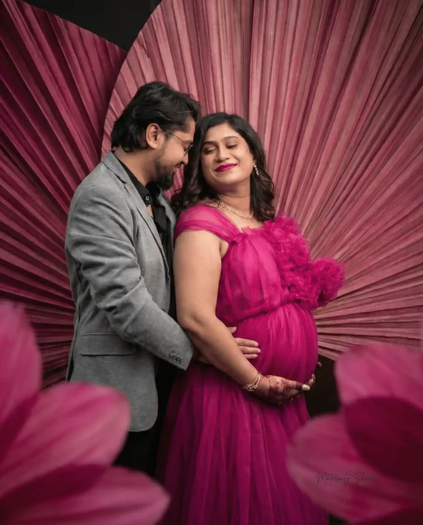 indoor maternity photoshoot in Kolkata with couple in pink designer gown